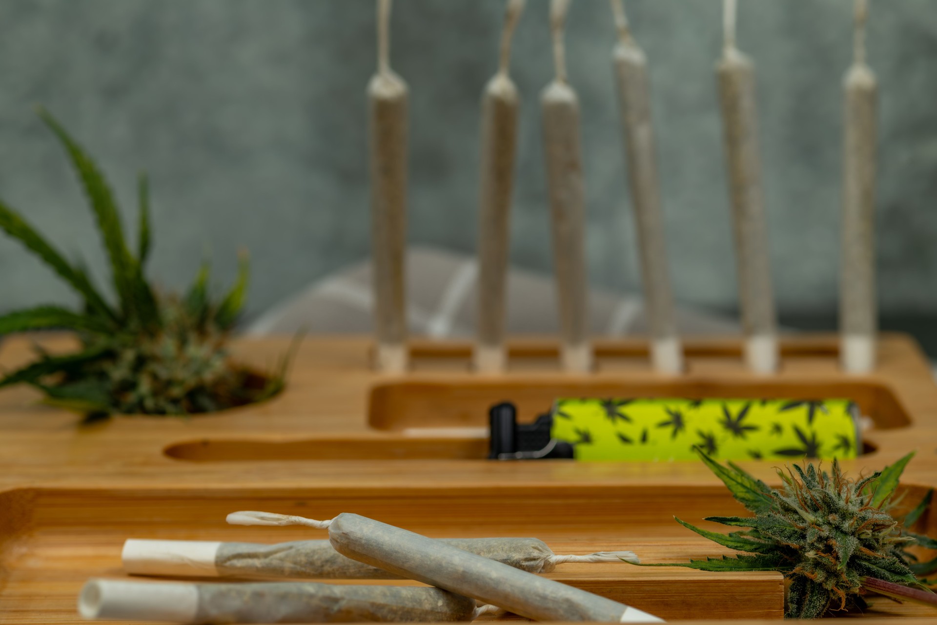Wooden light color box with joints and fresh marijuana and stone wall